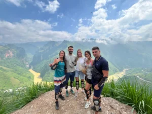 5 khách hàng người Pháp của loop trails hostel hà giang chụp ảnh trên đèo mã pí lèng với với view background là hẻm vực tu sản và sông nho quế