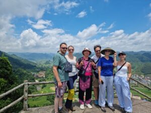 ảnh hướng dẫn viên của loop trails tours ha giang chụp cùng khách hàng tại núi đôi quản bạ hà giang