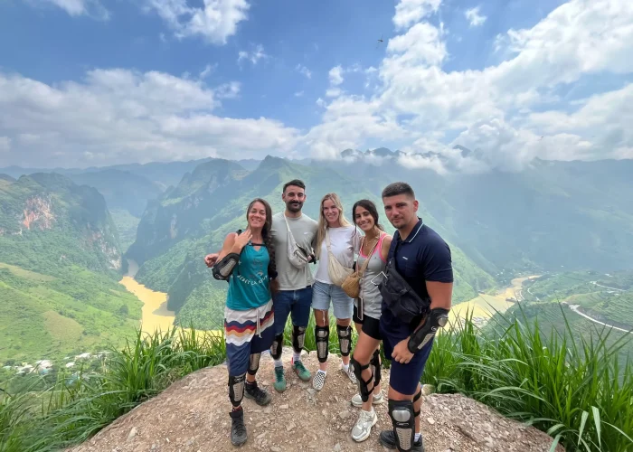 5 khách hàng người Pháp của loop trails hostel hà giang chụp ảnh trên đèo mã pí lèng với với view background là hẻm vực tu sản và sông nho quế