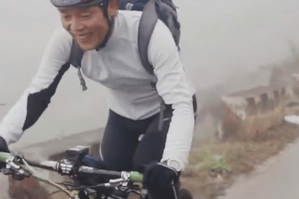 Cyclist ascending Quan Ba Pass on Ha Giang Loop cycling route