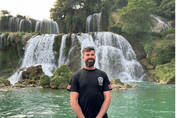 tourist on a boat in ban gioc waterfall with looptrails