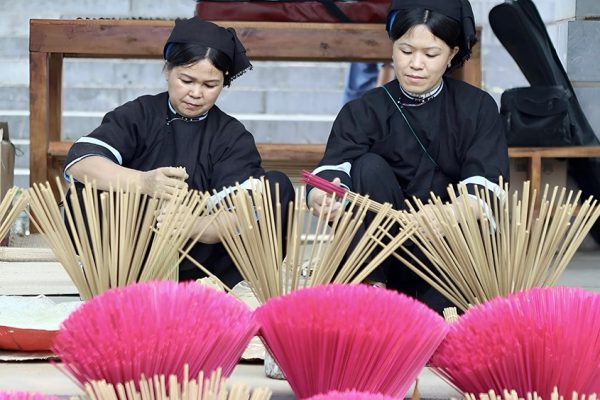 Tay ethnic woman tending incense drying Phia Thap Cao Bang Vietnam