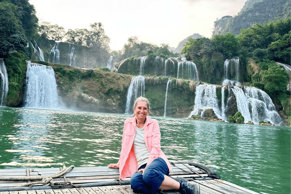tourist on a boat in ban gioc waterfall with looptrails